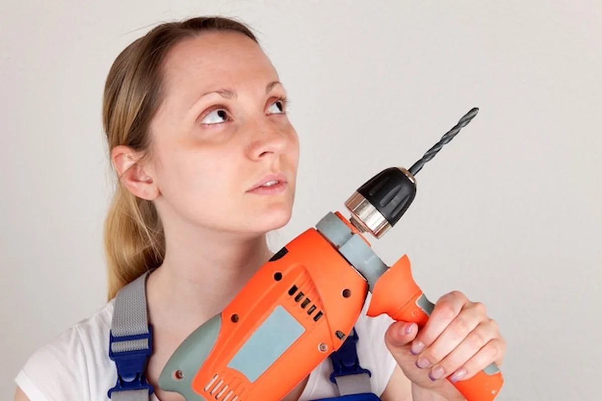 Młoda kobieta trzymająca wiertarkę